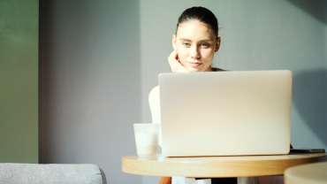 žena sediaca za počítačom a číta si maily